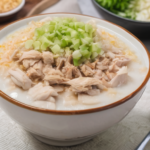 bubur ayam porsi mangkuk besar dengan suwiran ayam sebagai topping